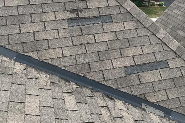 Wind damage and asphalt shingle deterioration in the roof valley